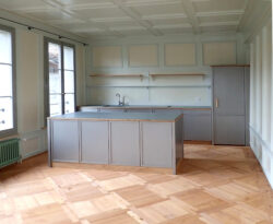 Küchenbau in 300-jährigem Berner Mehrfamilienhaus Die Top-Malerarbeit ergänzt die Küche perfekt. Oder ist es umgekehrt? Kochergut, perlmausgrau Ander Granit