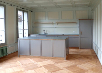 Küchenbau in 300-jährigem Berner Mehrfamilienhaus Die Top-Malerarbeit ergänzt die Küche perfekt. Oder ist es umgekehrt? Kochergut, perlmausgrau Ander Granit