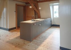 Küchenbau in 300-jährigem Berner Mehrfamilienhaus Ausbau Dachgeschoss Kochergut, perlmausgrau Ander Granit